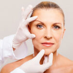 surgeon doing skin check on mid age woman before plastic surgery